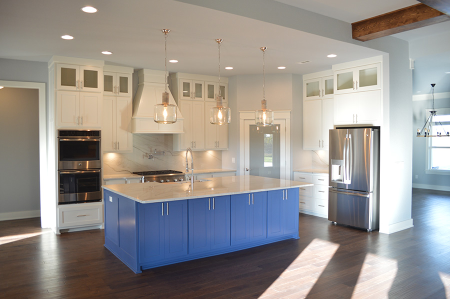 White theme kitchen with blue island and open floor