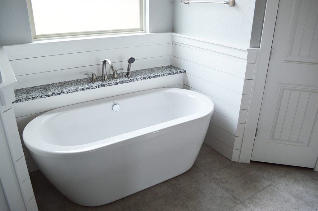 White bath tub with marble grey tile floor
